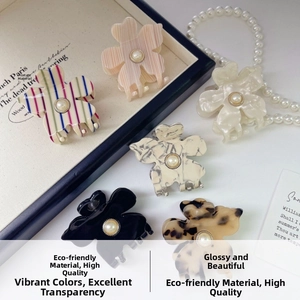 Detailed macro of six acetate flower hair claws with pearl centers in various colors