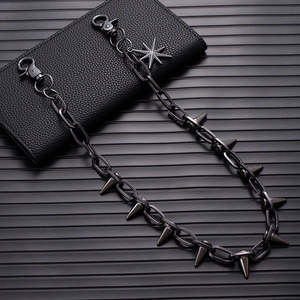 Detail of gunmetal punk trousers chain with metal spikes and an eight-pointed star pendant