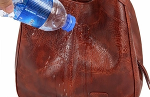 Macro shot showcasing water-resistant texture on red-brown vintage leather bucket bag