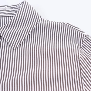 Macro detail of vertical striped shirt showing high-quality fabric texture and point collar