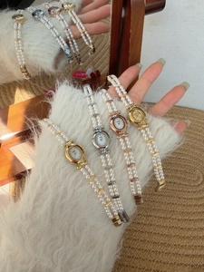 Detail of elegant pearl strap watches with oval mother-of-pearl dials in retro style