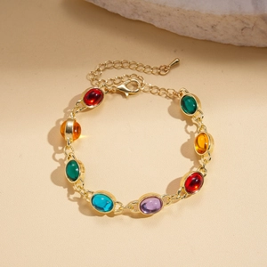 Close-up of golden chain necklace with colorful oval resin gemstones in vintage style