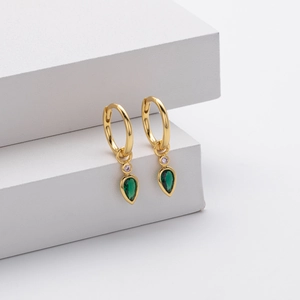 Detail of 18K gold huggie earrings featuring a teardrop-shaped deep green zircon drop