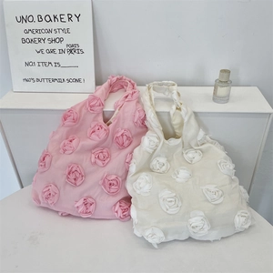 Detail of pink and beige canvas tote bags with 3D fabric rose flower decorations