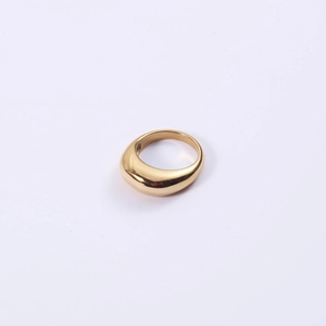 Detail of a minimalist gold ring with a polished curved teardrop design on purple background