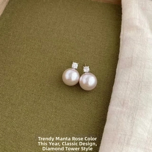 Macro detail of Manta Rose pearl earrings with brilliant zircon stones on dark fabric