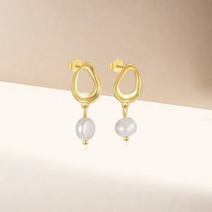 Detailed view of S925 sterling silver hallmarking on a gold hoop with baroque pearl