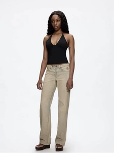 Detailed view of a black halter neck crop top paired with khaki straight leg jeans