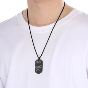 Macro shot of black rectangle pendant with DAD engraving on man wearing white t-shirt