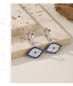 Macro detail of S925 silver evil eye drop earrings with blue and white zircons