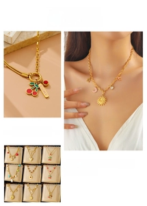 Detail of gold double-layer chain necklaces with cherry, sun, and heart-shaped charms