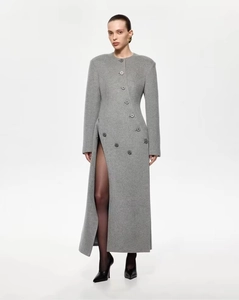 Détail de manteau gris en laine avec boutonnage multiple et fente latérale haute
