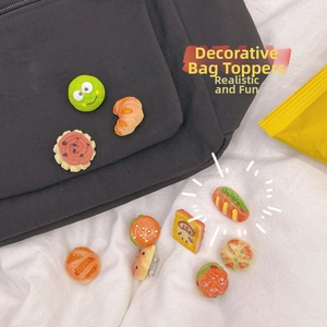 Detail of realistic food pins and frog badge attached to a black fabric backpack
