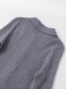 Detail of cable knit texture and faux pearl accents on the grey knit sweater collar