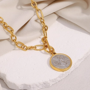 Macro detail of retro two-tone 18K gold and silver angel coin pendant necklace