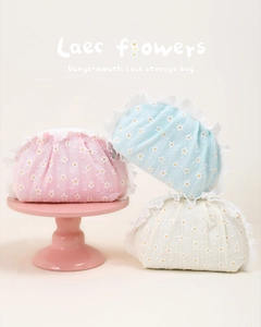 Close-up of daisy embroidered mesh storage bag with white pleated lace trim and zipper