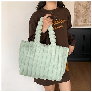 Detail showing plush mint green striped faux fur texture on a large shoulder tote bag