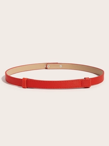 Detail of red Saffiano leather skinny belt with adjustable metal buckle closure