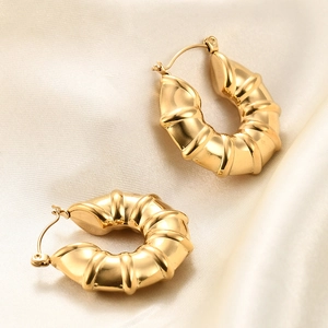 Minimalist gold U-shaped striped earrings with vintage polished metal texture