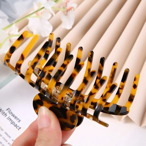 Macro detail of large tortoiseshell hair claw clip with dense teeth and metal spring