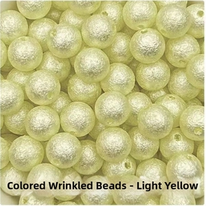 Macro detail of light yellow ABS imitation pearls with unique wrinkled texture for DIY jewelry