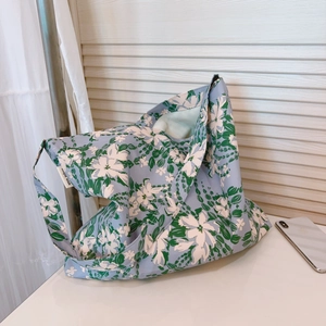 Dettaglio della borsa tote in tela a fiori azzurra con etichetta e trama del tessuto fine