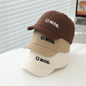 Close-up of three cotton twill baby caps with NICE smile embroidery in brown and khaki