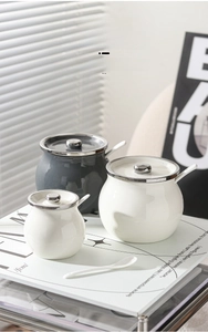 Close-up of ceramic lard jars with airtight metal lids and matching porcelain spoons