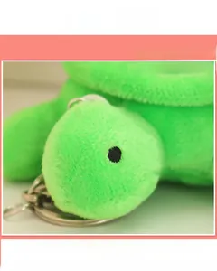 Close-up of cute green plush turtle keychain with soft fabric and detailed embroidery