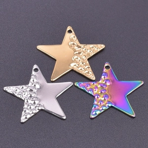 Vue macro de pendentifs étoile en or, argent et arc-en-ciel avec détails texturés