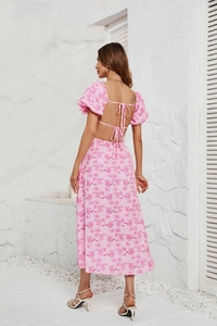 Detail of pink floral midi dress featuring a low back design and tie-back ribbons