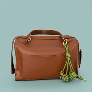 Borsa a mano in pelle marrone con ciondolo decorativo a nappa intrecciata verde