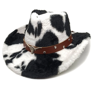 Detail of cow print cowboy hat featuring a silver bull head metal emblem and studded band