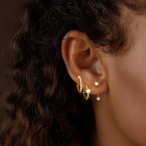 Detailed view of model wearing gold S925 silver hoop earrings and zircon stud set