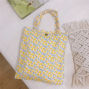 Gros plan d'un mini cabas en toile à motif citron avec un fermoir à pression en bronze