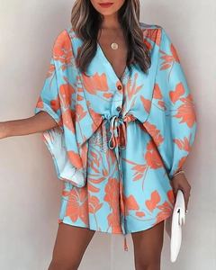 Detail of V-neck floral summer dress showing sky blue fabric and orange flower patterns