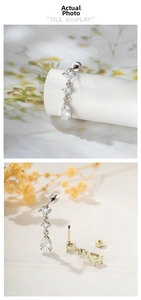 Detail of three-tier zircon drop earrings with screw back design in gold and silver