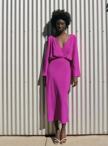 Detail of rose red deep V-neck maxi dress with long flare sleeves and elegant waist design