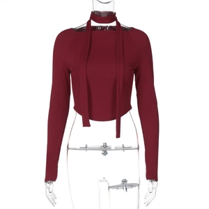 Dettaglio del crop top bordeaux aderente con trama a costine e dettaglio fiocco al collo