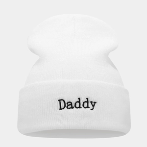 Close-up of white ribbed knit beanie with black Daddy embroidery on the folded cuff