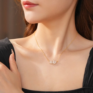 Gros plan d'un collier pendentif fleuri plaqué or avec cristaux brillants sur un mannequin