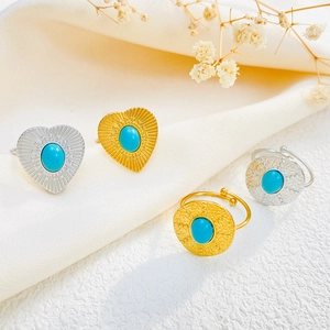 Detailed view of vintage gold and silver rings featuring blue turquoise heart and round stones