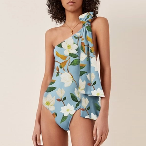 Detail of light blue floral swimsuit featuring one-shoulder design and large bow accent