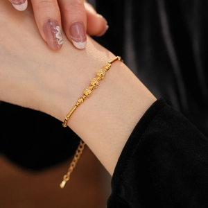 Detail shot of 18K gold plated bamboo bracelet with sparkling white zircon charms