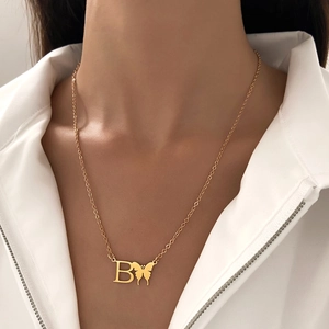 Elegant gold stainless steel necklace featuring a letter B and butterfly pendant on a model