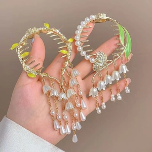 Dettaglio di fermagli per capelli mughetto con perle e foglie verdi placcati oro