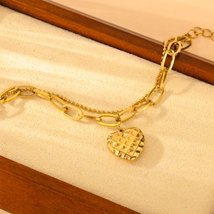 Double-layer gold heart bracelet with a textured grid pendant and mixed metal chains