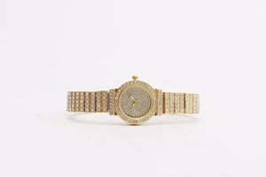 Detailed macro view of luxury women's watch with full crystal rhinestones on gold band