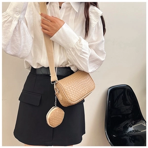 Close-up of beige woven texture shoulder bag with matching round coin purse detail