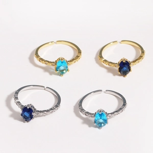 Detail of blue zircon rings showing gold and silver bands with oval cut gemstones